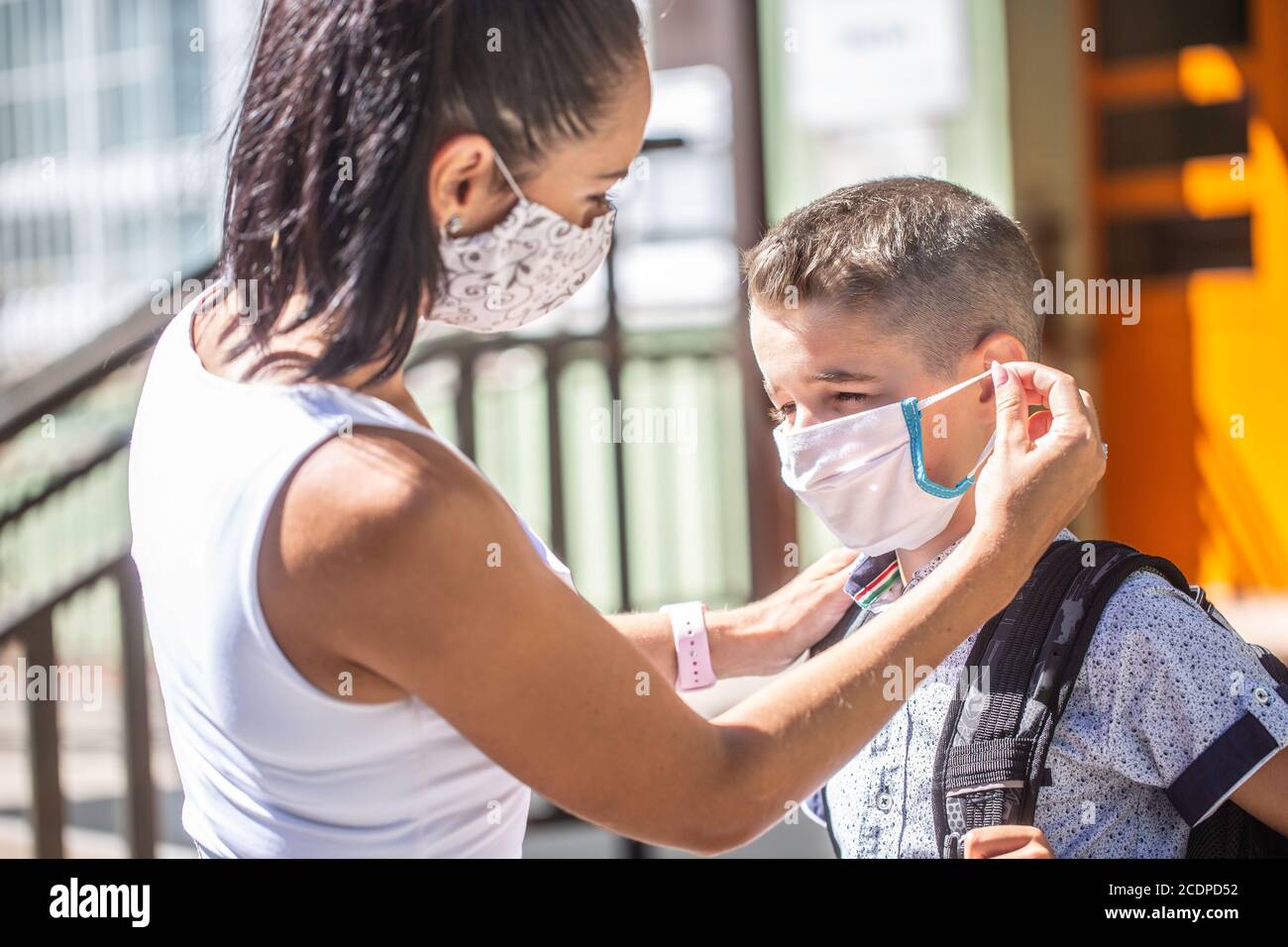 Eine Mutter und ihr Sohn verwenden eine Schutzmaske, wenn sie während der COVID-19-Quarantäne zur Schule zurückkehren. Stockfoto