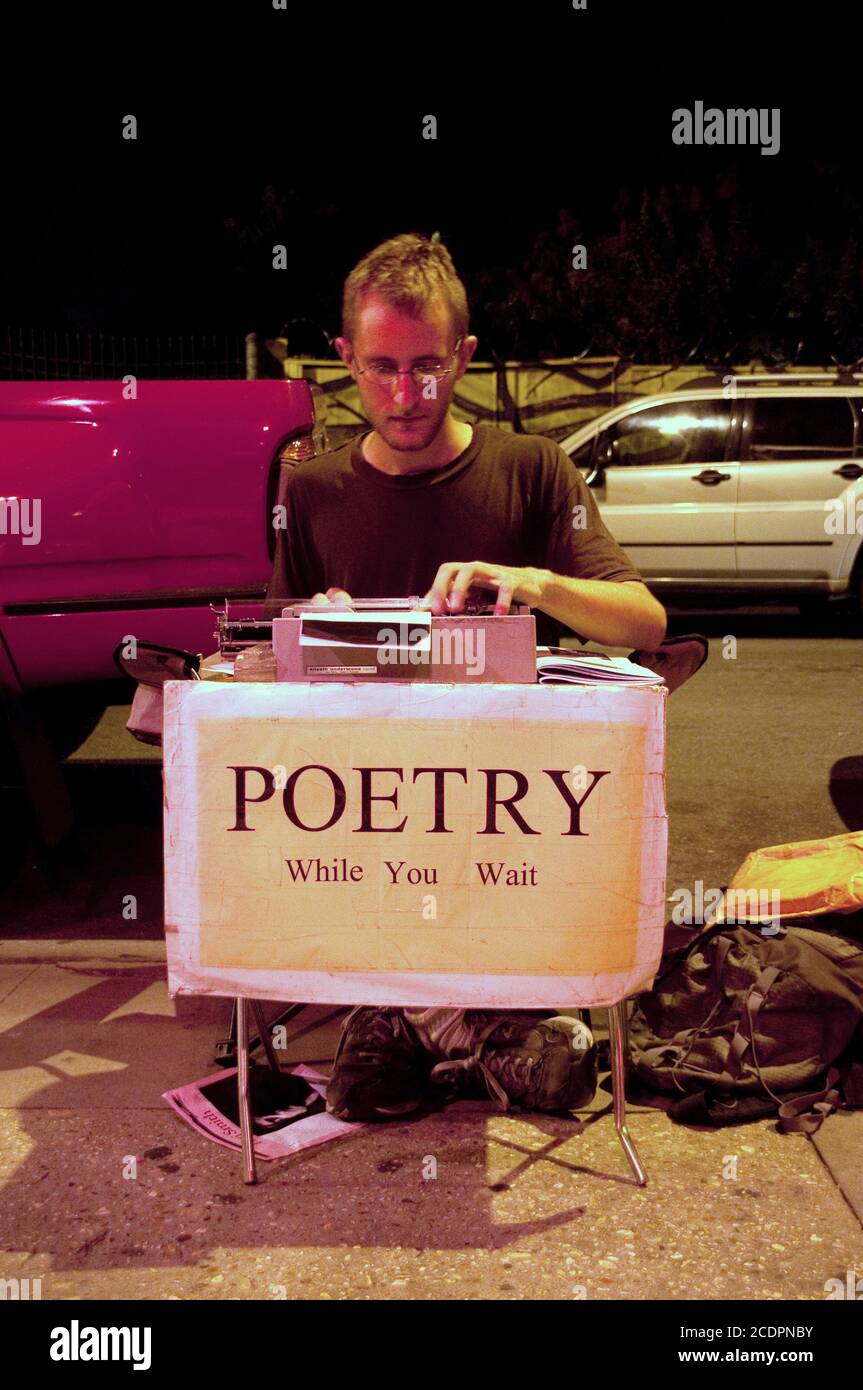 Ein junger freiberuflicher Schriftsteller und Dichter sitzt an seiner Schreibmaschine auf der Straße im Viertel Marigny-Bywater in New Orleans, Louisiana, USA. Stockfoto