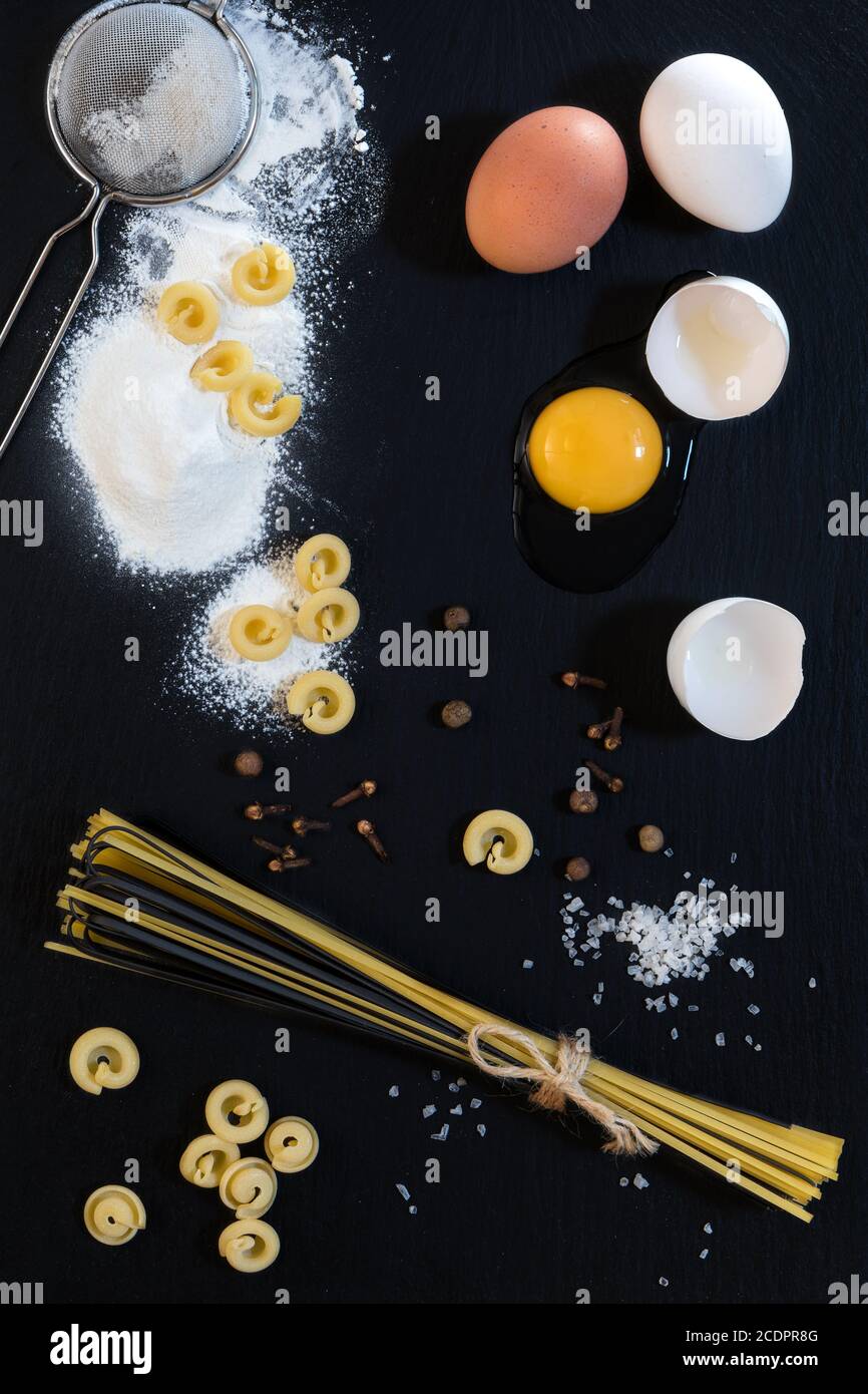 Traditionelle und schwarze ungekochte italienische Pasta Linguine mit weißen und Braune Hühnereier Stockfoto