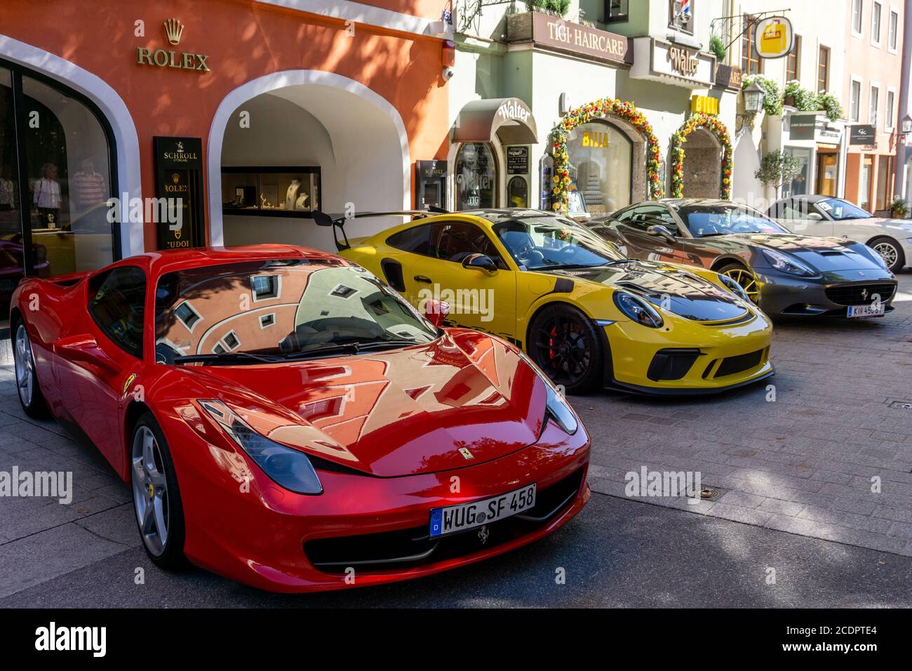 Kitzbühel, Österreich - 30.09.2018: Ferrari und Porsche parkten vor dem Rolex Store in Österreich Stockfoto