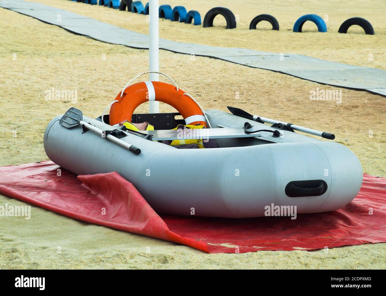 Aufblasbares Rettungsboot. Graues Schlauchboot am Strand im Sand Stockfoto