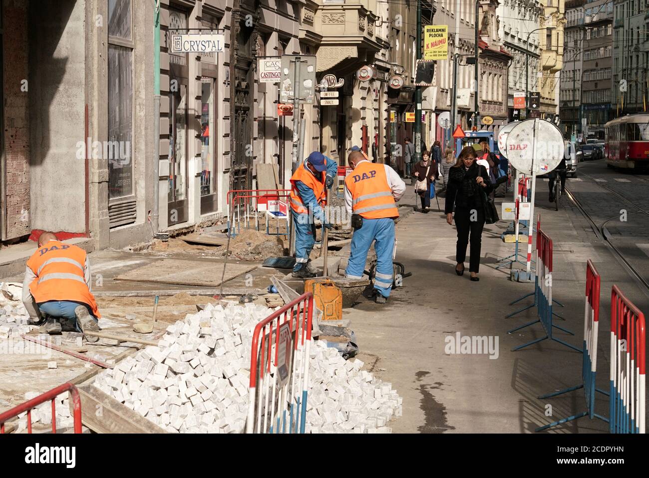 Die Bauarbeiter renovieren einen Gehweg mit Pflastersteinen im Stadtzentrum von Prag. Stockfoto