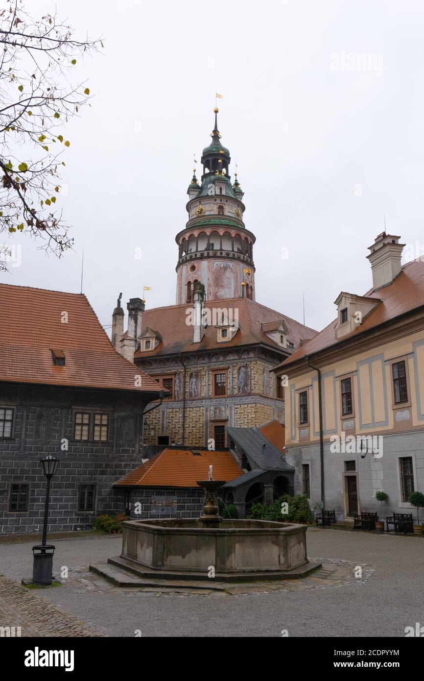 Ein kleiner Brunnen mit der Burg Cesky Krumlov und Turm Im Hintergrund Stockfoto