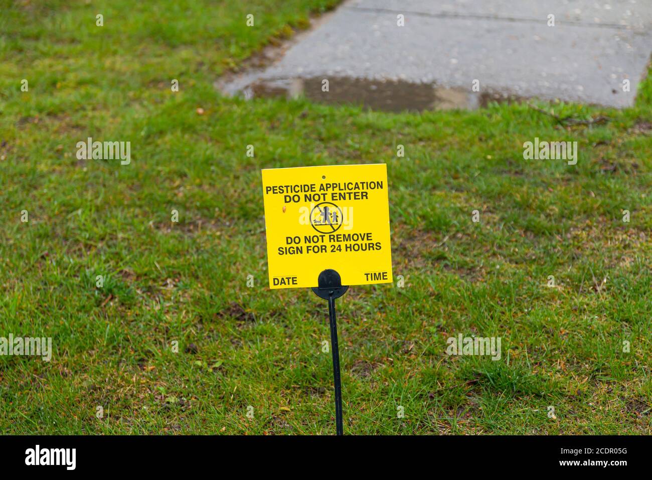 Ein kleines gelbes Schild ist auf der Vorderseite Rasen platziert Agter chemischen Pestizid wurde als Warnung an Komm nicht herein. angewendet Stockfoto