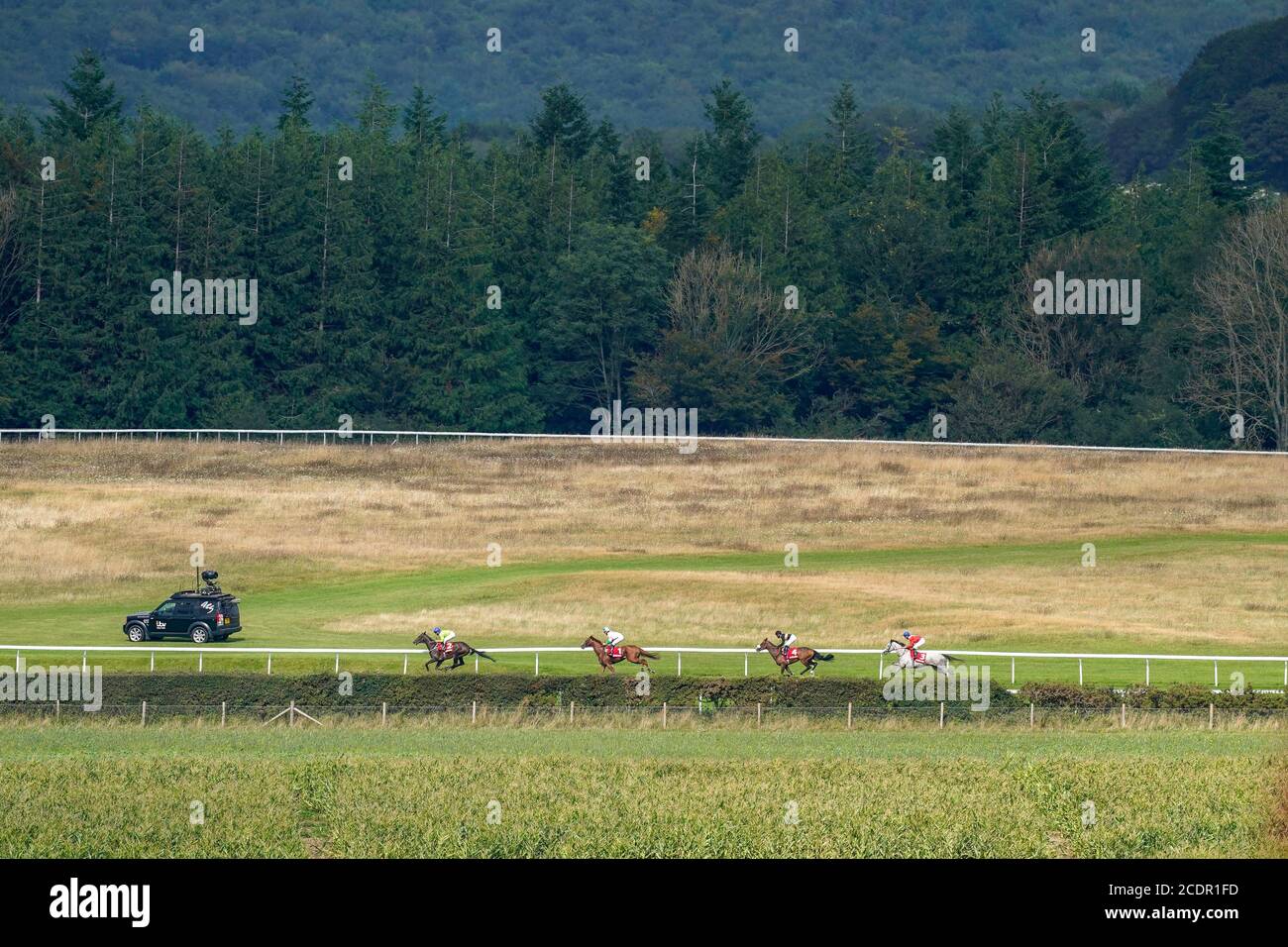 Der ITV Racing Truck folgt der Aktion als Subjektivist, der von Jockey Joe Fanning (zweiter links) auf dem Weg zum Ladbrokes March Stakes auf der Goodwood Racecourse gefahren wird. Stockfoto