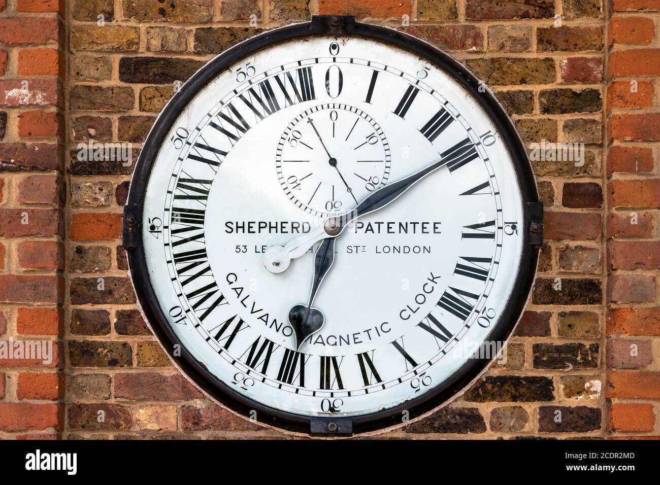 Die Shepherd Gate Clock ist an der Wand außerhalb des Tores des Royal Greenwich Observatory in London montiert. Es ist ungewöhnlich, da es eine vierundzwanzig ho hat Stockfoto