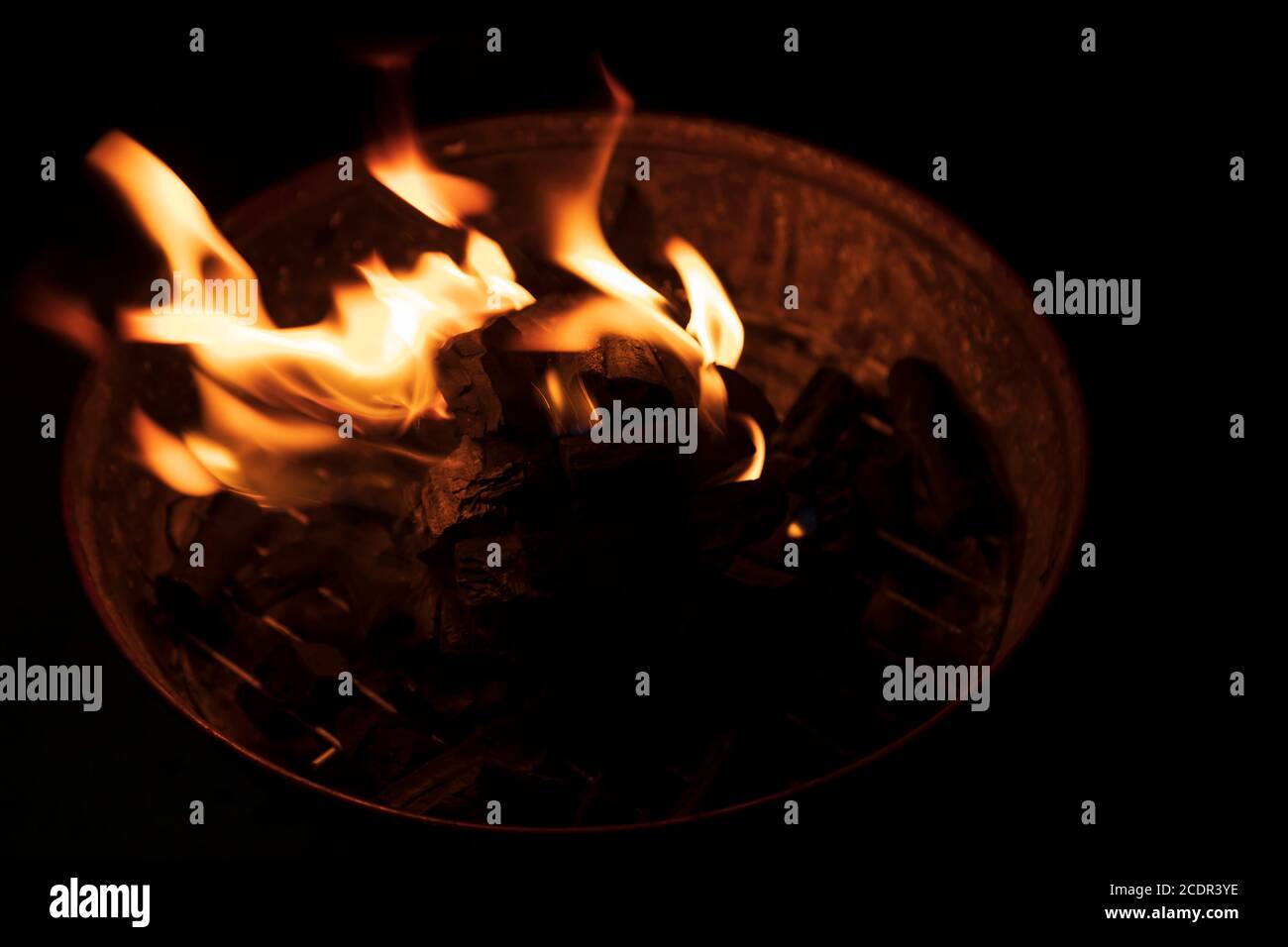 Flammen, die von einem Holzkohlenfeuer ausgehen, das gerade gewesen ist In einem Grill Stockfoto