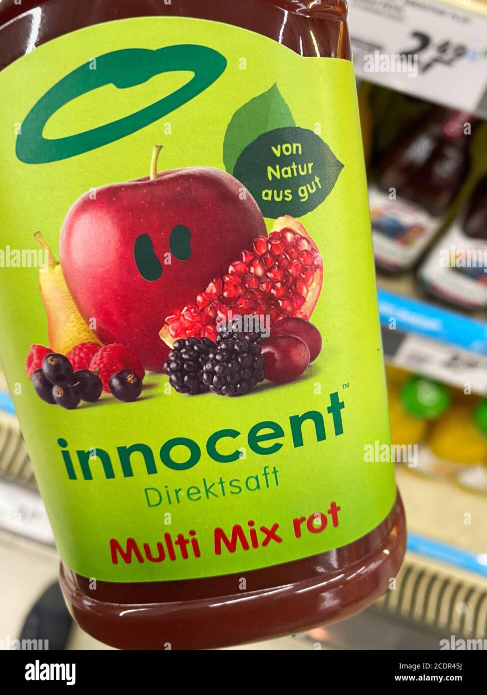 Viersen, Deutschland - 9. August. 2020: Blick auf Hand halten Flasche unschuldigen Multivitamin Fruchtsaft im deutschen Supermarkt Stockfoto