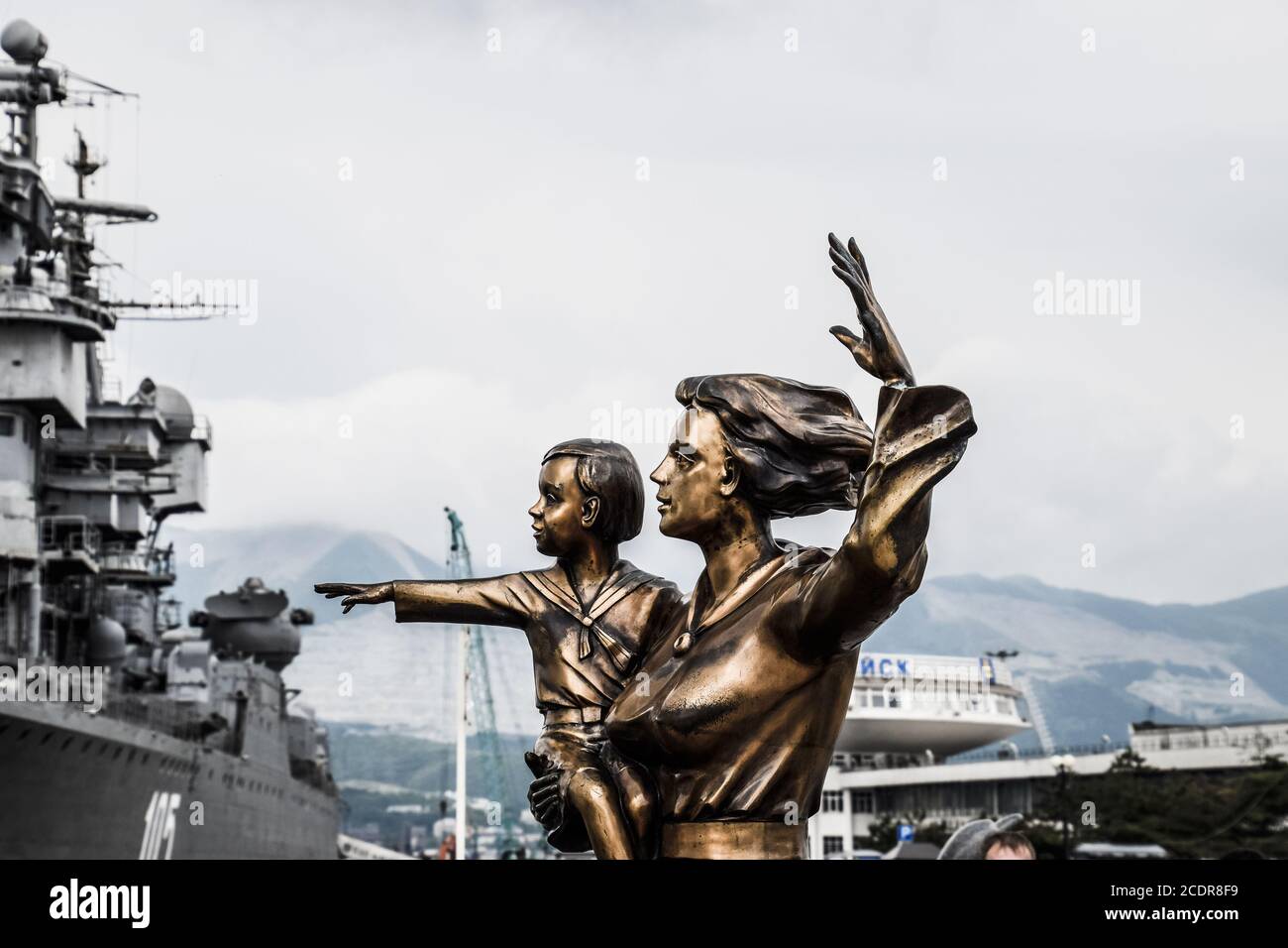 Denkmal für die Frau des Matrosen. Kriegsschiff Admiral Kutusov. Das Gebiet von Noworossijsk Meer Handelshafen. Stockfoto