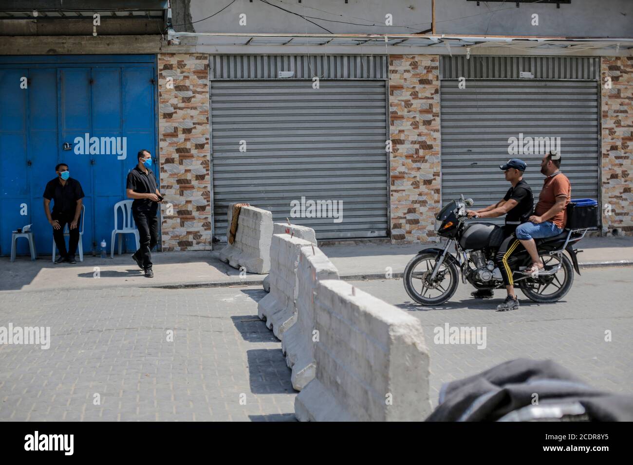 Gaza-Stadt, Der Gazastreifen, Palästina. August 2020. Palästinensische Hamas Polizisten stehen Wache in einer fast leeren Straße im Lager Jabalia im nördlichen Gazastreifen, 29. August 2020. Der Gazastreifen wird nach der Entdeckung der ersten Fälle von Infektionen mit dem pandemischen SARS-CoV-2-Coronavirus, das die COVID-19-Krankheit verursacht, landesweit gesperrt.Quelle: Mahmoud Issa/Quds Net News/ZUMA Wire/Alamy Live News Stockfoto