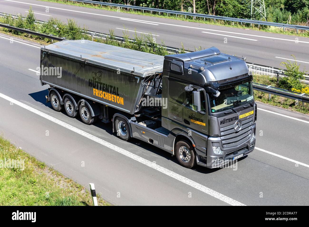 Hüttental Mercedes-Benz Actros LKW mit Kippanhänger auf der Autobahn. Stockfoto
