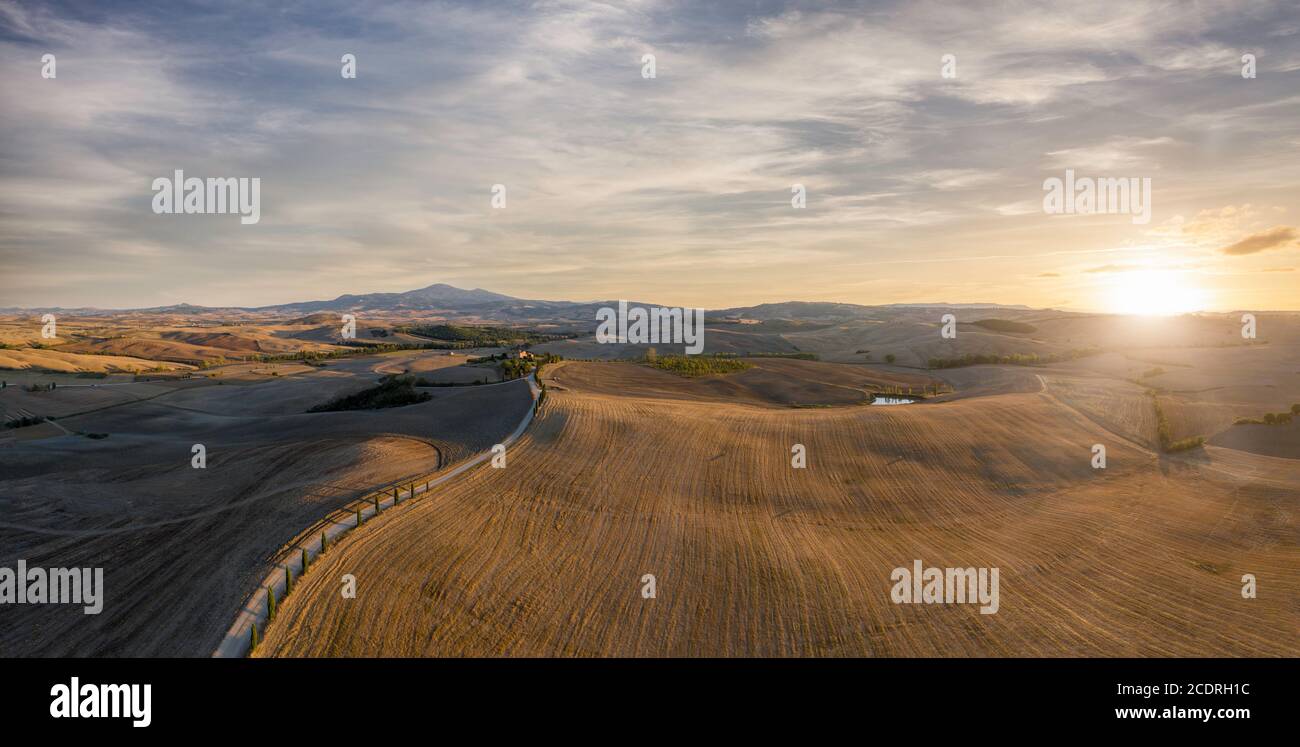 Luftpanorama von schönen Sonnenuntergang über toskanischen Hügeln, Bauernhöfe, Zypressen gesäumten Straßen Stockfoto