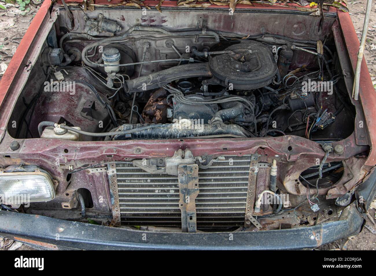 Eine offene Haube eines alten Autos mit Blick auf die Überreste des Motors. Stockfoto