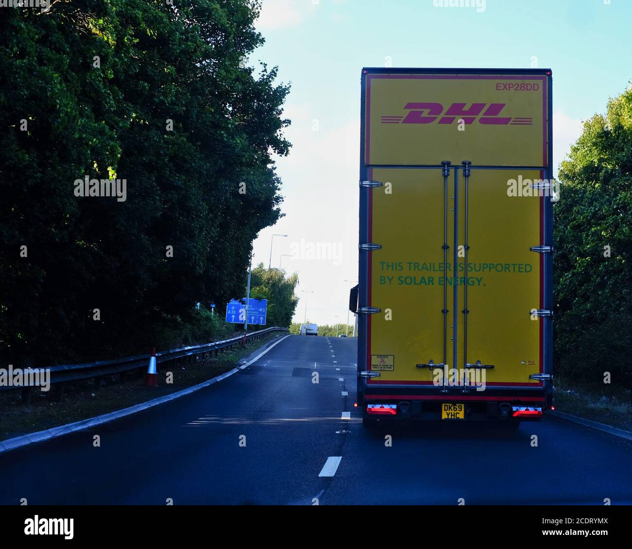 DHL LKW-Anhänger unterstützt durch Solarenergie, um die Umweltauswirkungen des Güterverkehrs zu reduzieren. Stockfoto