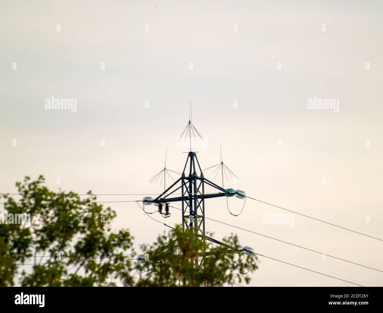 Stromturm bei Sonnenuntergang auf dem Land mit Bäumen in Spanien Stockfoto