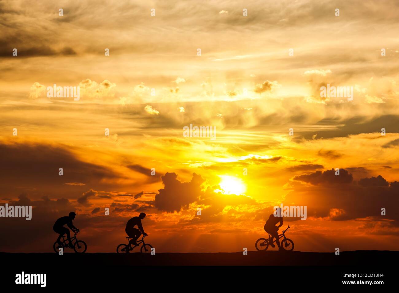 Freunde auf einer Radtour bei Sonnenuntergang. Aktiver Lebensstil, Radfahren Hobby. Stockfoto