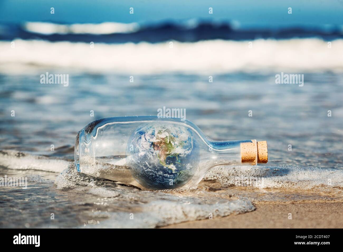 Die Erde in der Flasche kommt mit der Welle aus dem Ozean. Umwelt, saubere Welt Botschaft Stockfoto