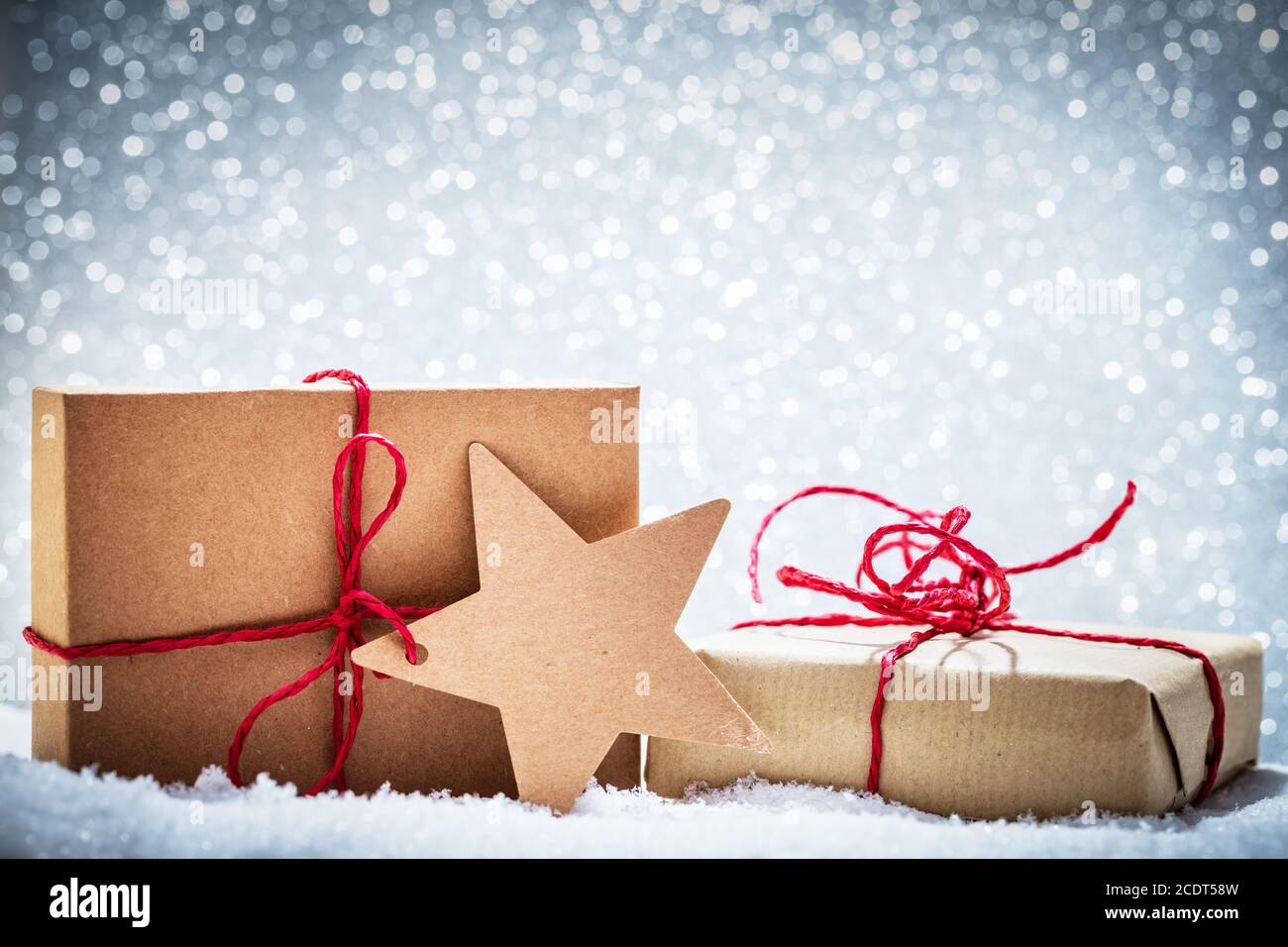 Retro rustikale Weihnachtsgeschenke, Geschenke im Schnee auf Glitzer-Hintergrund Stockfoto