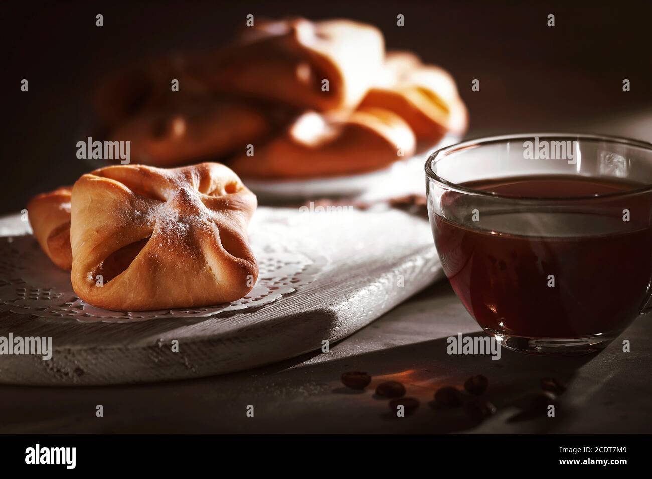 Hausgemachtes süßes Gebäck für Kaffee. Frisches, köstliches Gebäck auf dem Tisch serviert mit Kaffee. Das Licht aus dem Fenster fällt auf den Tisch. Stockfoto