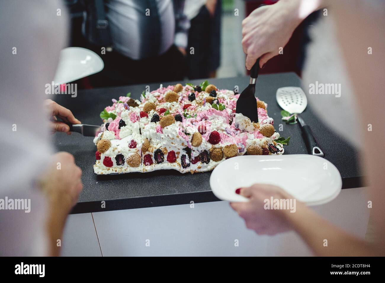 Stilvolle wunderschöne Braut und Bräutigam schneiden und Verkostung ungewöhnliche weiße Hochzeitstorte. POV anzeigen Stockfoto