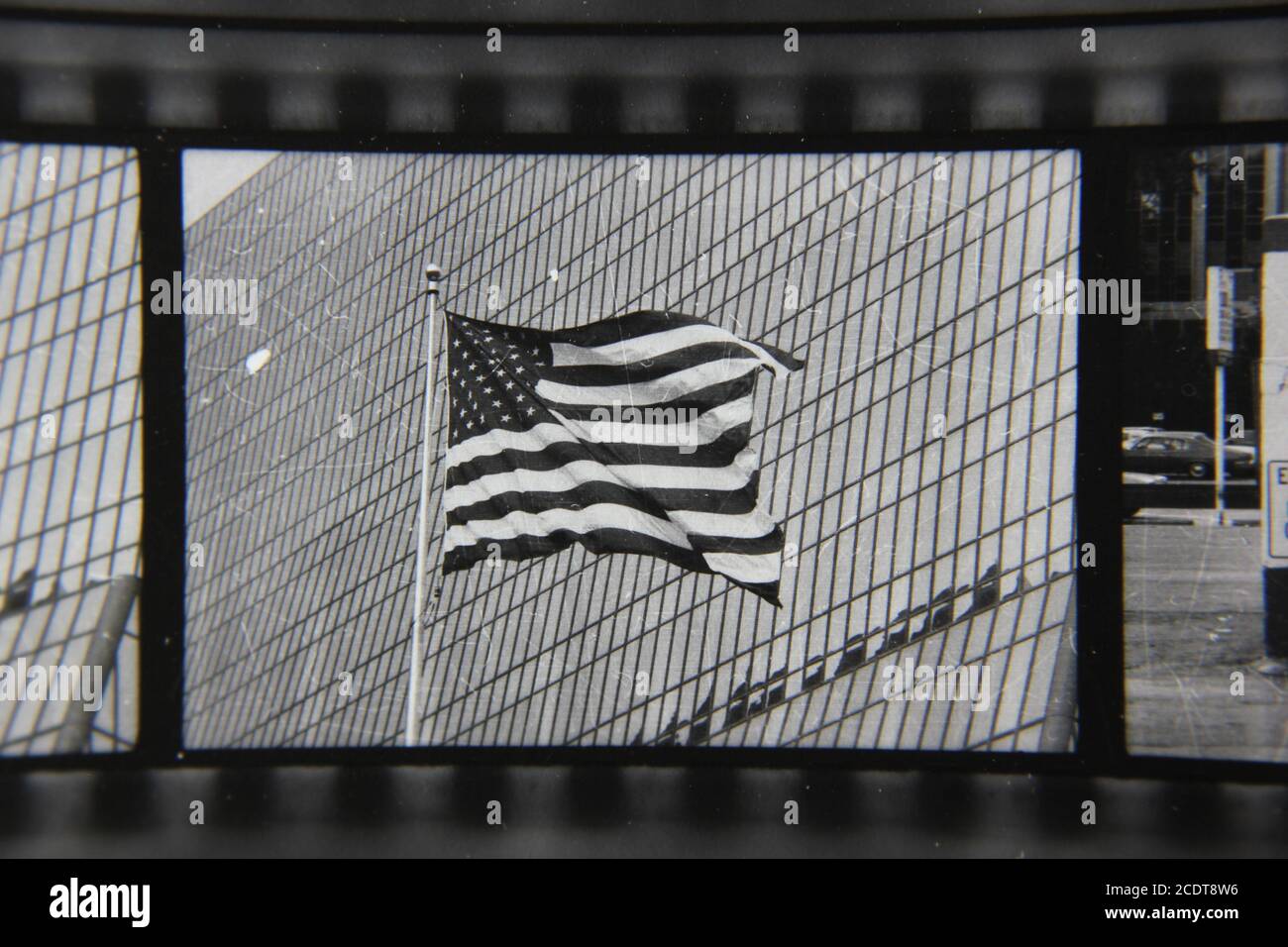 Feine Schwarz-Weiß-Fotografie aus den 1970er Jahren einer Flagge der Vereinigten Staaten, die in der Brise vor einem Bürogebäude winkt. Stockfoto