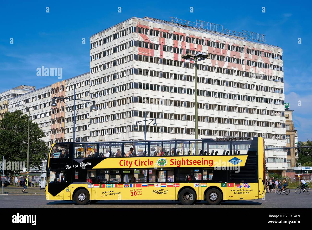 Touristen bei einer Stadtrundfahrt durch die Straßen Berlins In einem gelben Bus Stockfoto