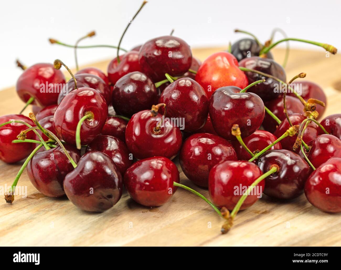 Süße Kirschen auf einem Holzteller Stockfoto