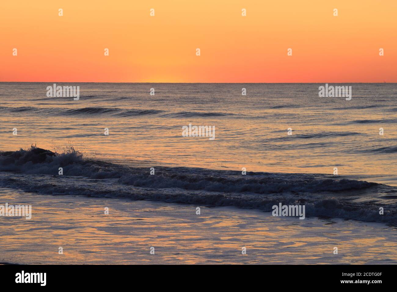 Der orange Schein der Sonne beginnt über dem Atlantischen Ozean in Avalon, New Jersey, USA aufzugehen Stockfoto