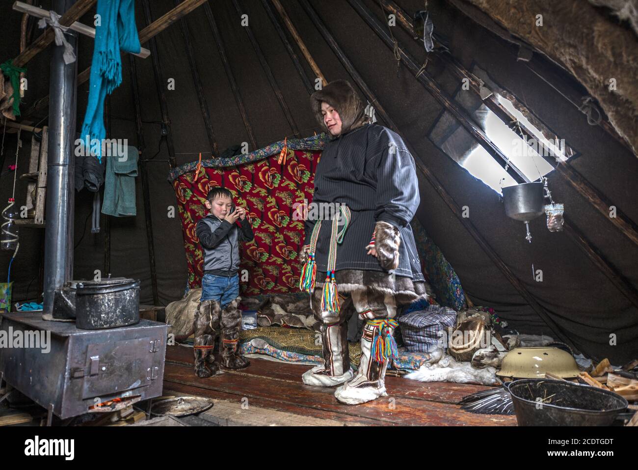 Ein Nenet Junge und Kind in einem Chum (traditionelles Zelt mit Rentierfellen bedeckt), Jamal-Nenets Autonomous Okrug, Russland Stockfoto