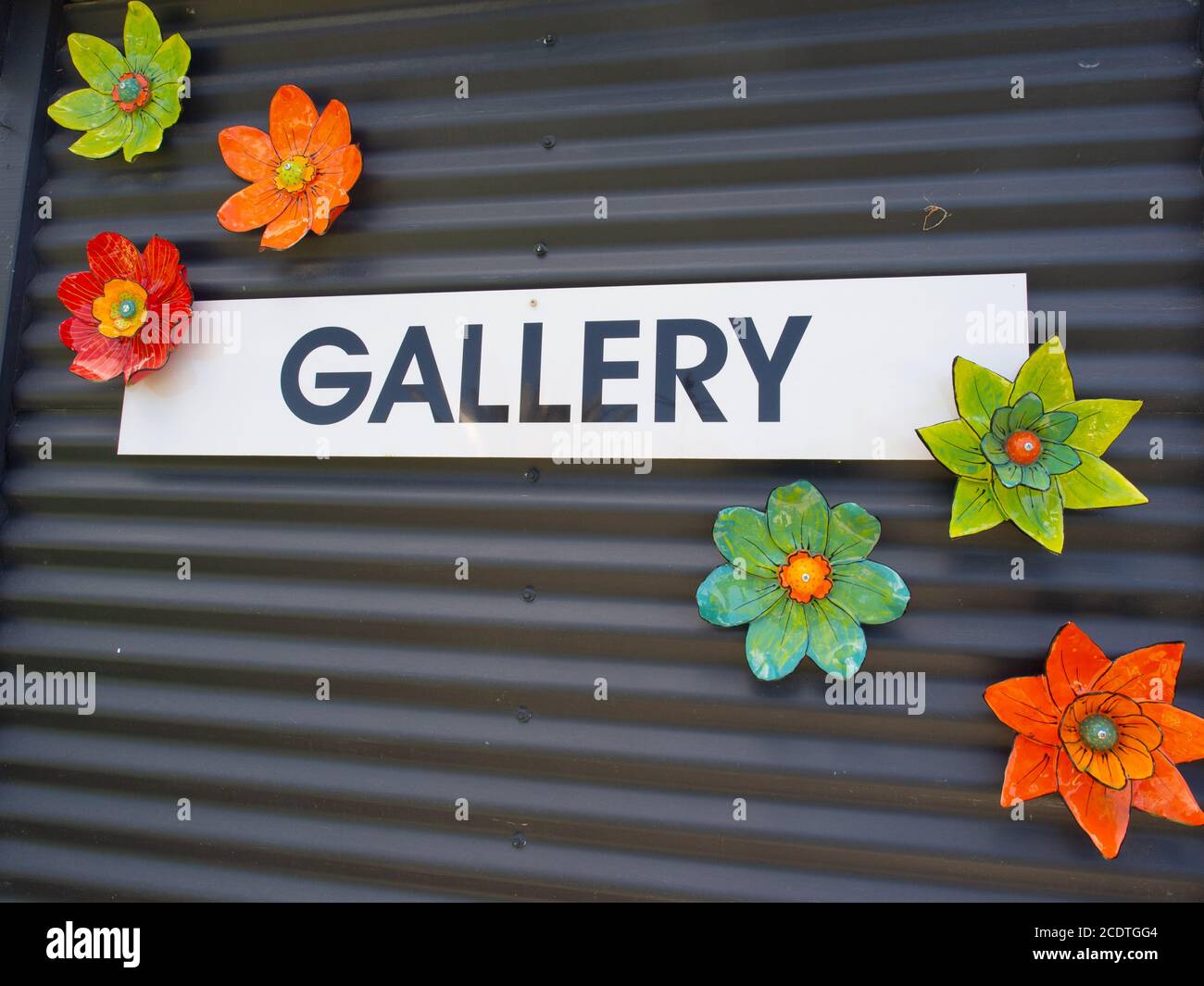 Galerie Schild und Keramikblumen an EINER schwarzen Wand Stockfoto