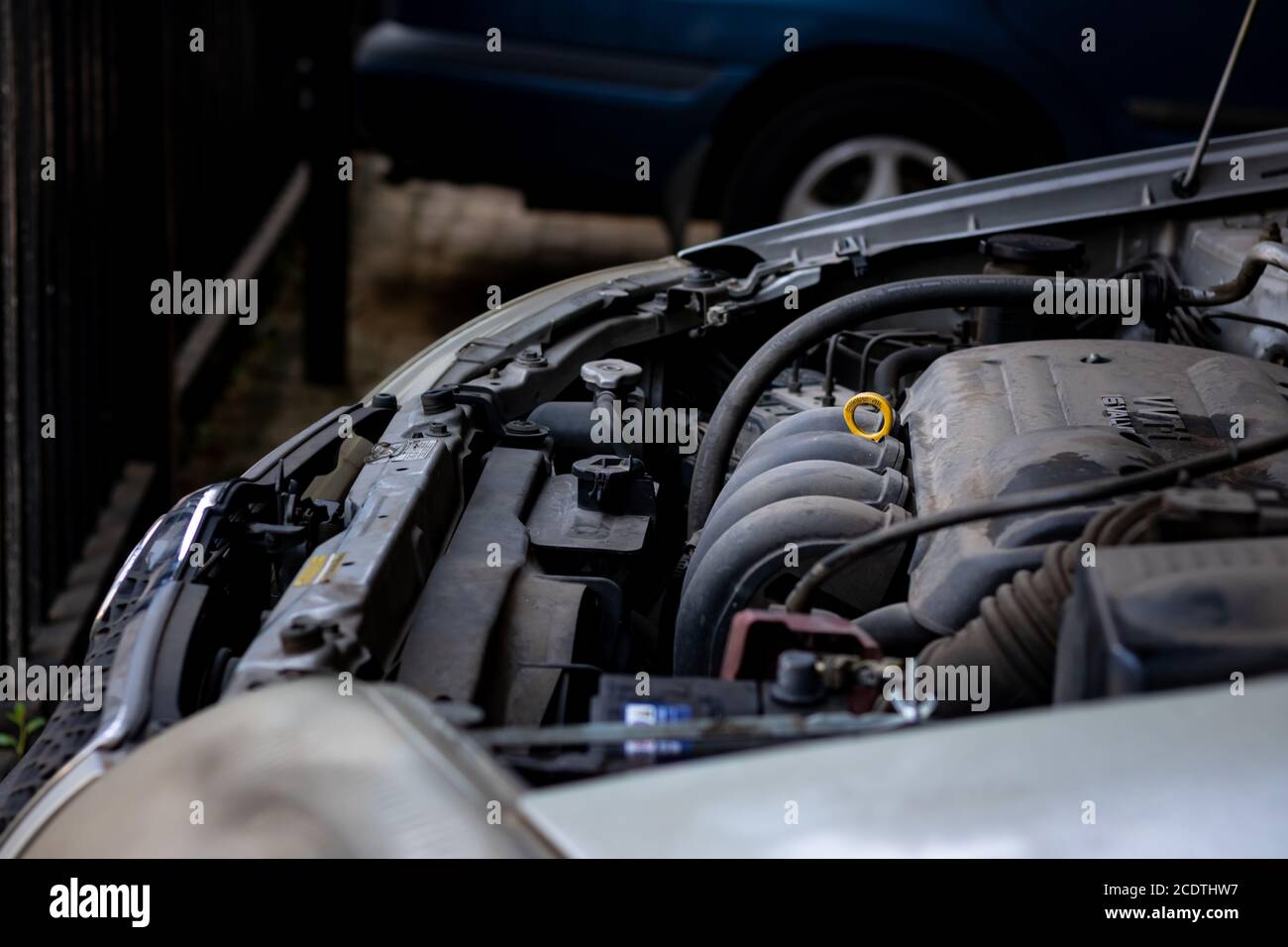 Alte schmutzige Auto-Motor in der Notwendigkeit einer Wäsche mit Ein gelber Öltauch-Stab Stockfoto