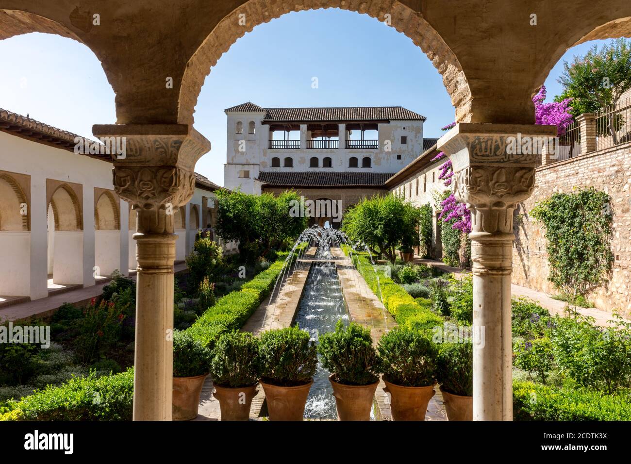 Blick auf den Innenhof des Generalife mit seinem berühmten Brunnen und Garten durch einen Bogen. Alhambra de Granada Komplex in Granada, S Stockfoto