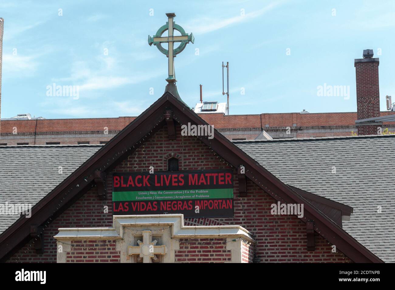 Ein Black Lives Matter Schild hängt über dem Eingang von Fort Washington Collegiate Church in Nord-Manhattan unter einem Kreuz Stockfoto