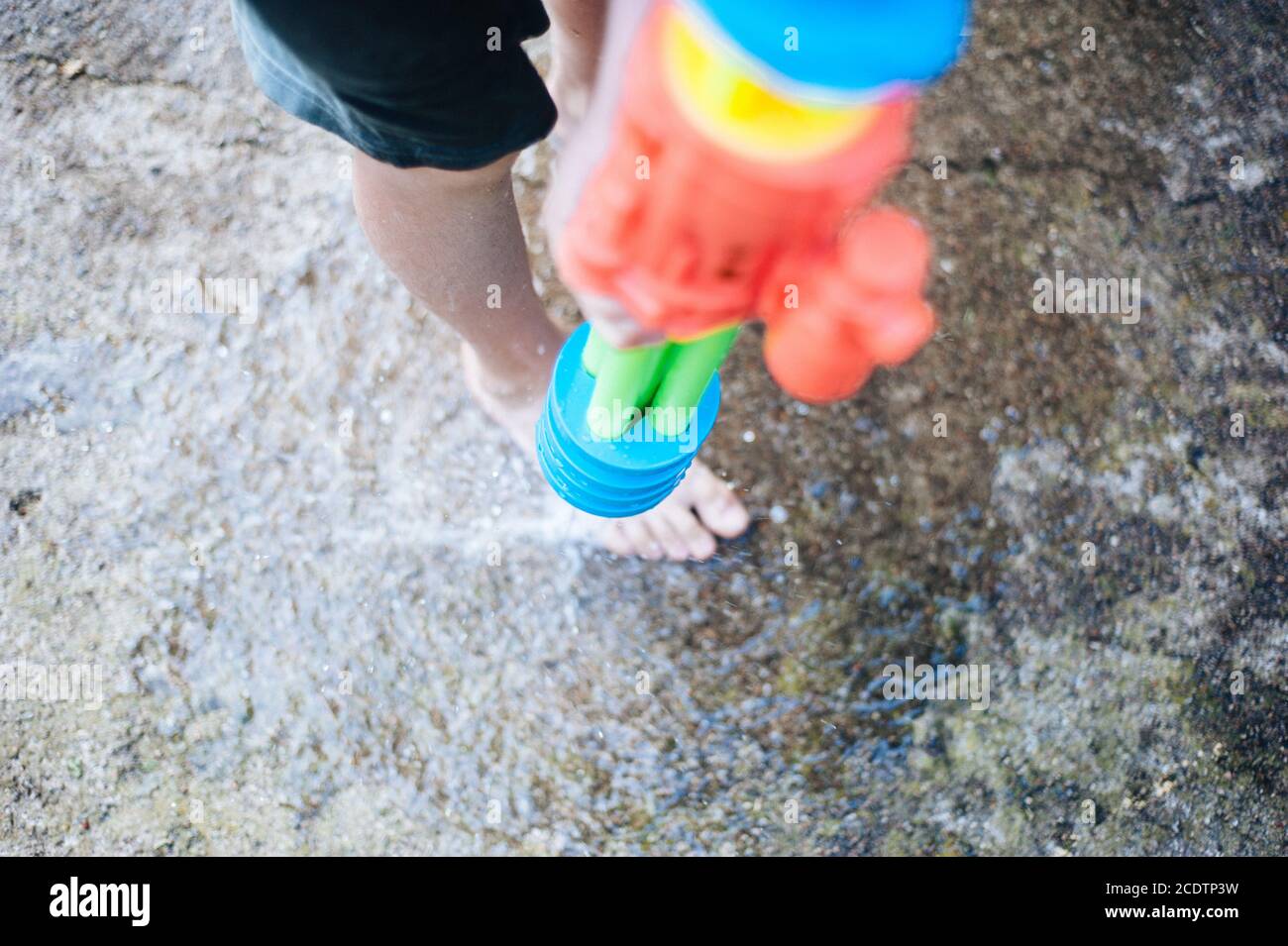 Kinder spielen im Garten mit Gewehren und Wassergewehren An einem sonnigen Sommertag Stockfoto