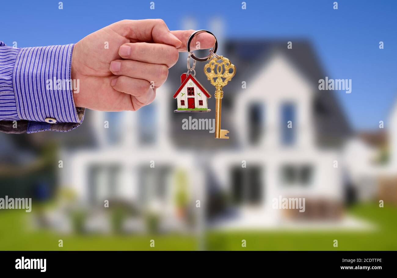 Schlüssel in der Hand von Real estate agent als Angebot für Ihr neues Zuhause Stockfoto