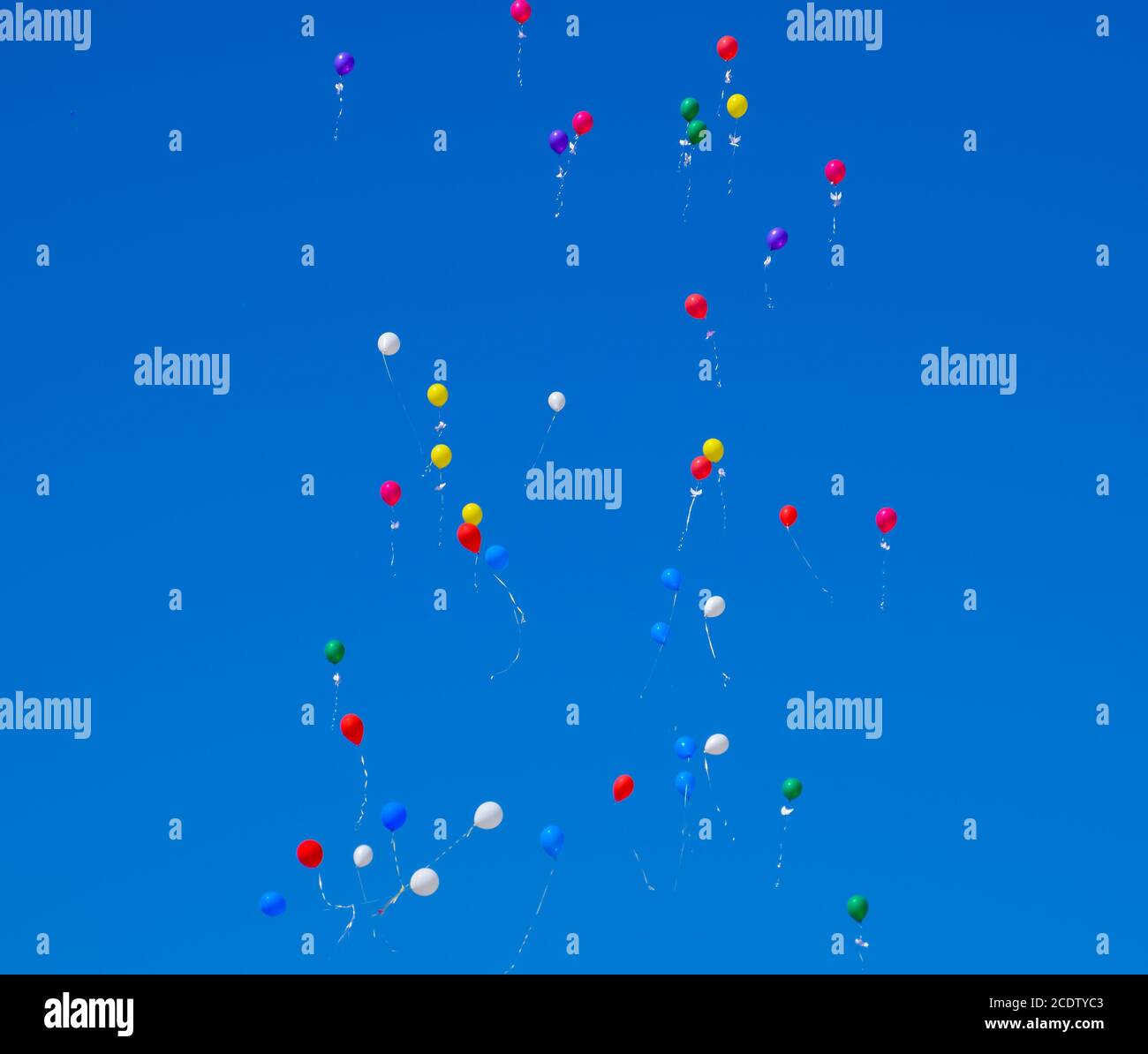 Bunte Kugeln, mit Helium gefüllt, Fliegen im blauen Himmel Stockfoto