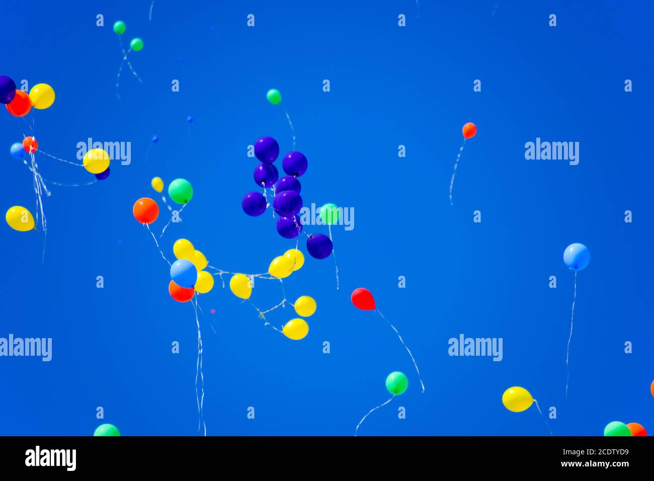 Bunte Kugeln, mit Helium gefüllt, Fliegen im blauen Himmel Stockfoto
