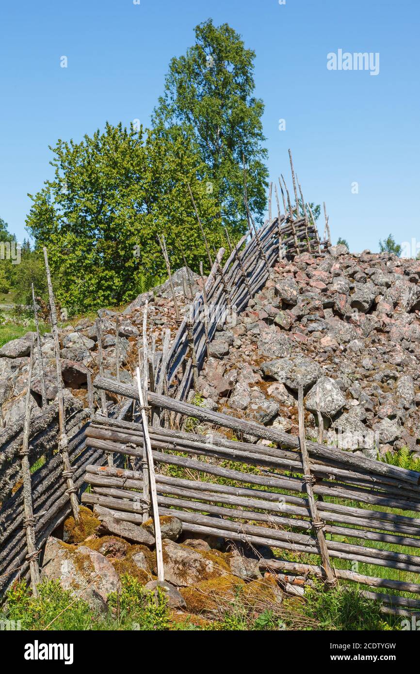 Runde pfosten Zaun über einen Haufen Steine in einem alten Landschaft Stockfoto