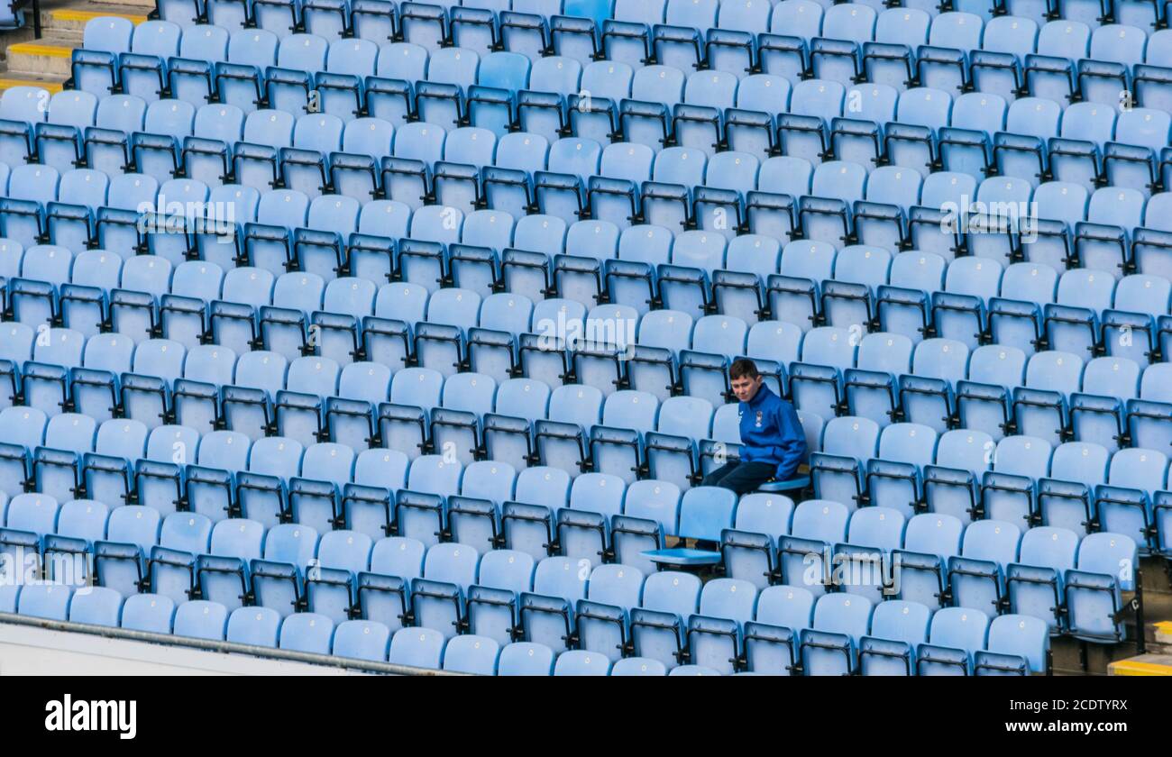 Reihen von Kunststoff blau Stadion sitze, mit einem Kind das Spiel ansehen. Stockfoto