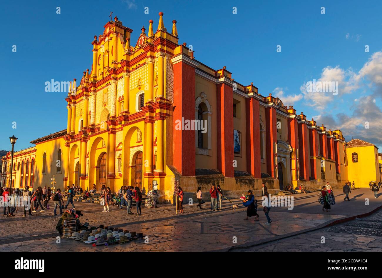 Mexikanisches Stadtleben mit Straßenverkäufern und Menschen an der Kathedralenfassade bei Sonnenuntergang, San Cristobal de las Casas, Mexiko. Stockfoto