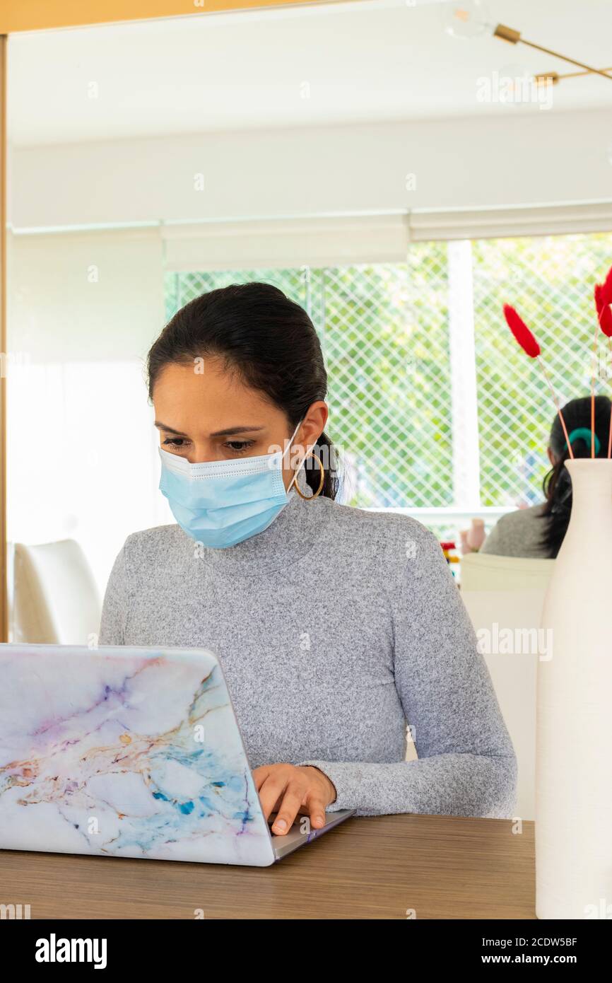 Schöne lateinische Frau, die Home Office für den Corona-Virus Pandemie Stockfoto