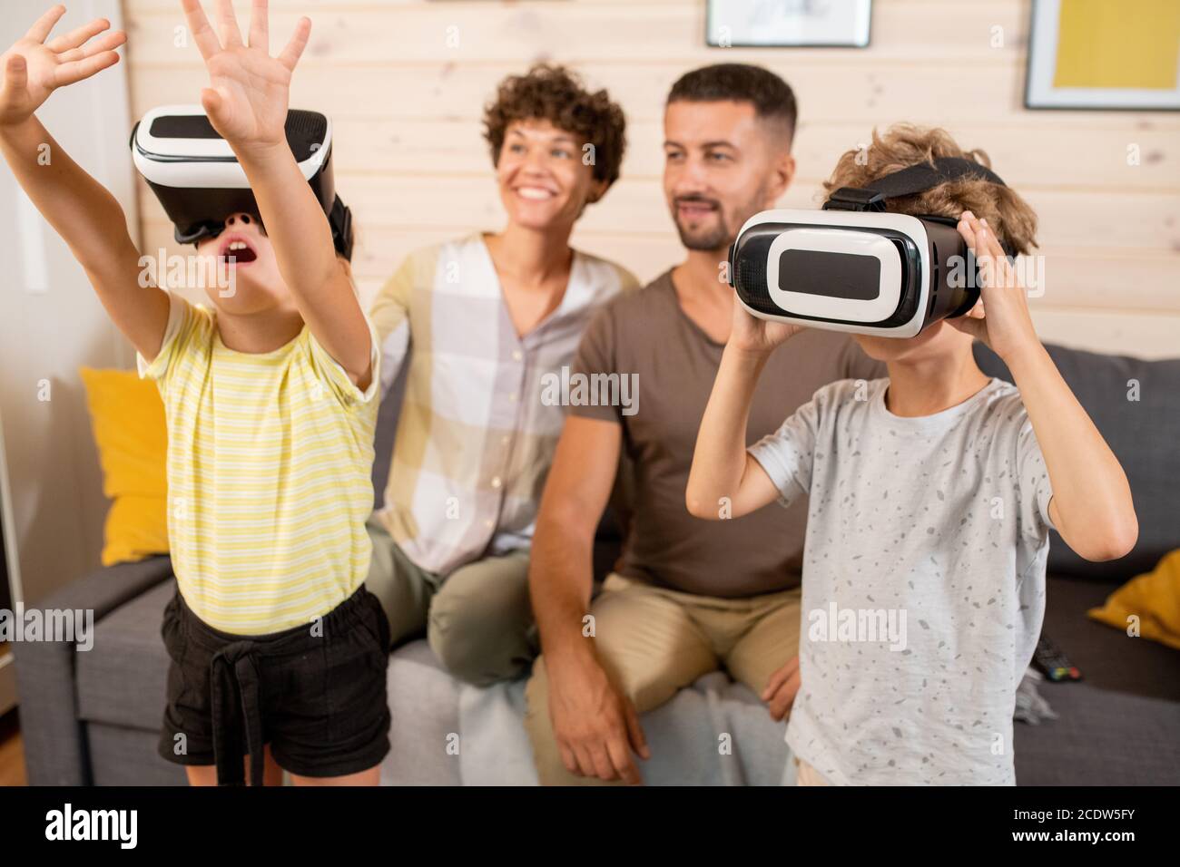 Kleiner Junge und Mädchen in vr Headsets beobachten neugierige Sachen Auf der virtuellen Anzeige Stockfoto