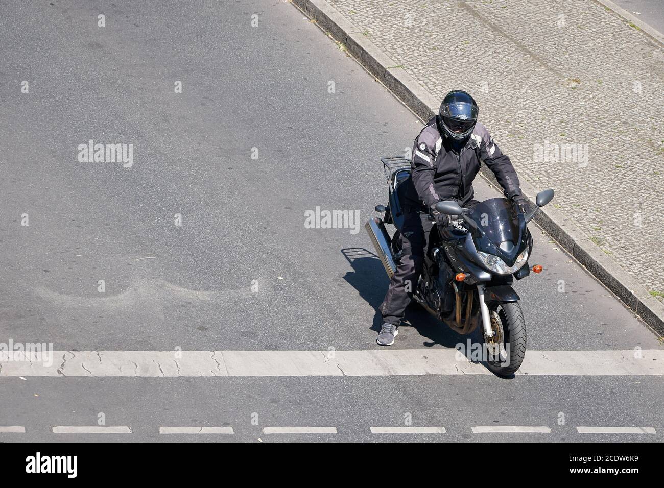 Motorradfahrer wartet an einer Kreuzung in der Stadtmitte von Berlin Stockfoto