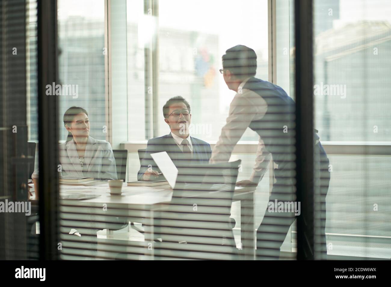 Ein Team asiatischer Geschäftsleute trifft sich aus dem Glas Im Büro Stockfoto