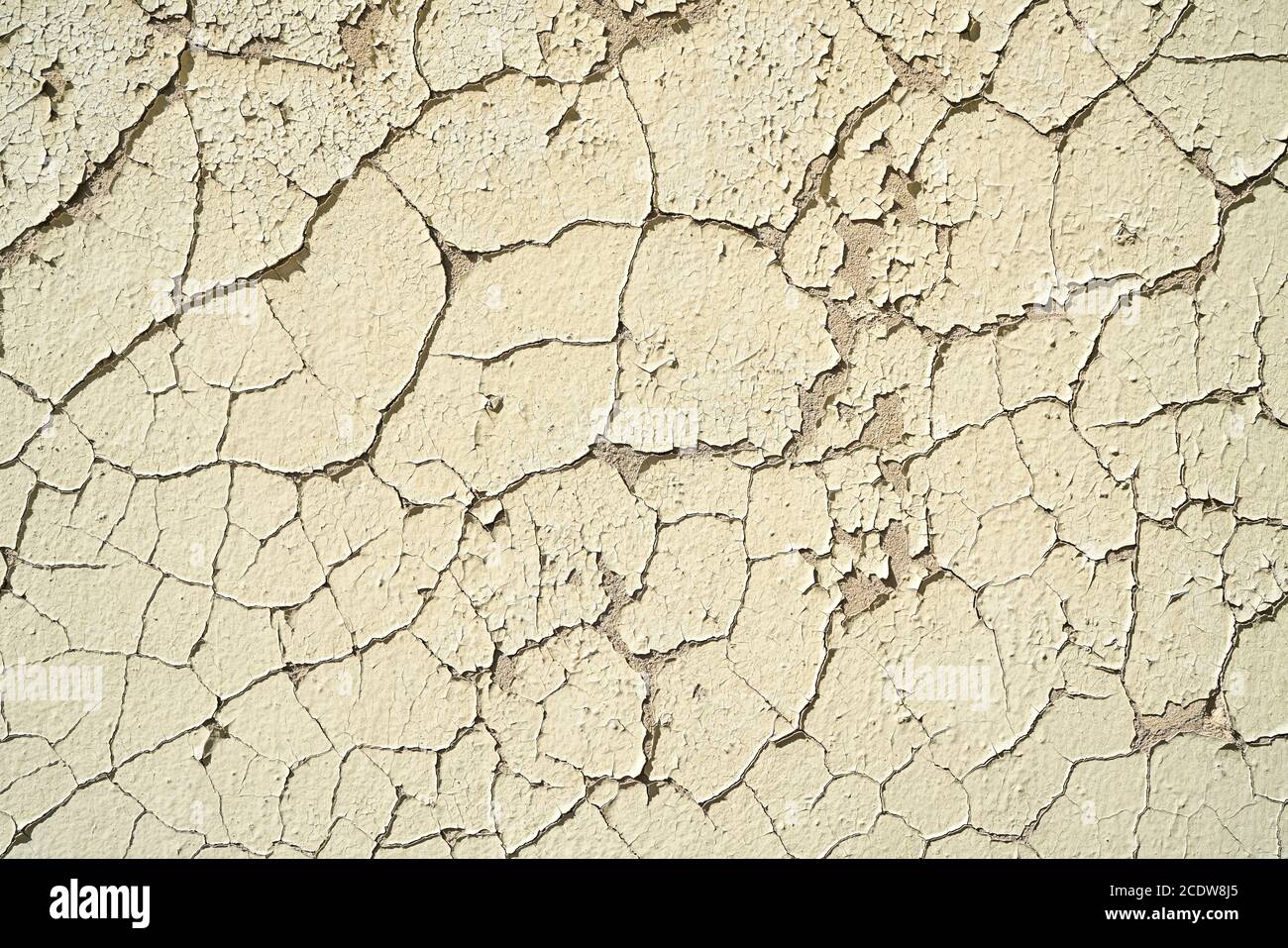 Die Farbe blättert an einer heruntergekommenen Hauswand mit Rissen ab Stockfoto