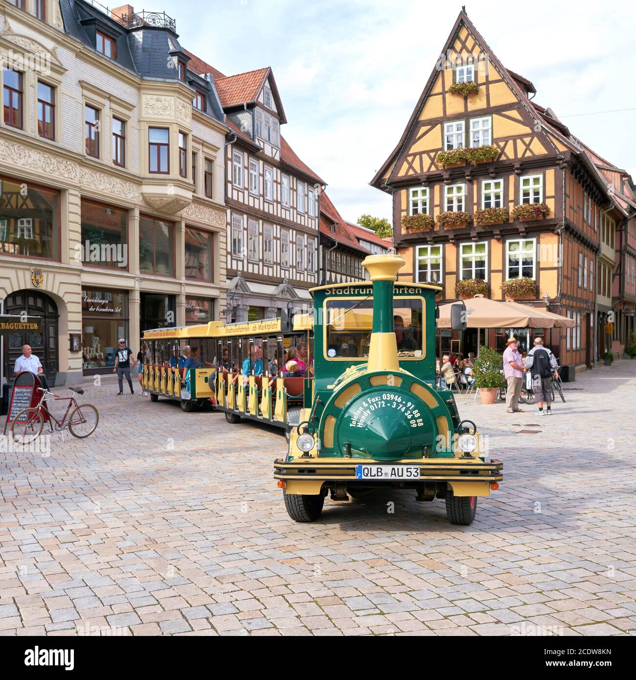 Touristen während einer Stadtrundfahrt durch die Altstadt von Quedlinburg mit einer Lokomotive Stockfoto