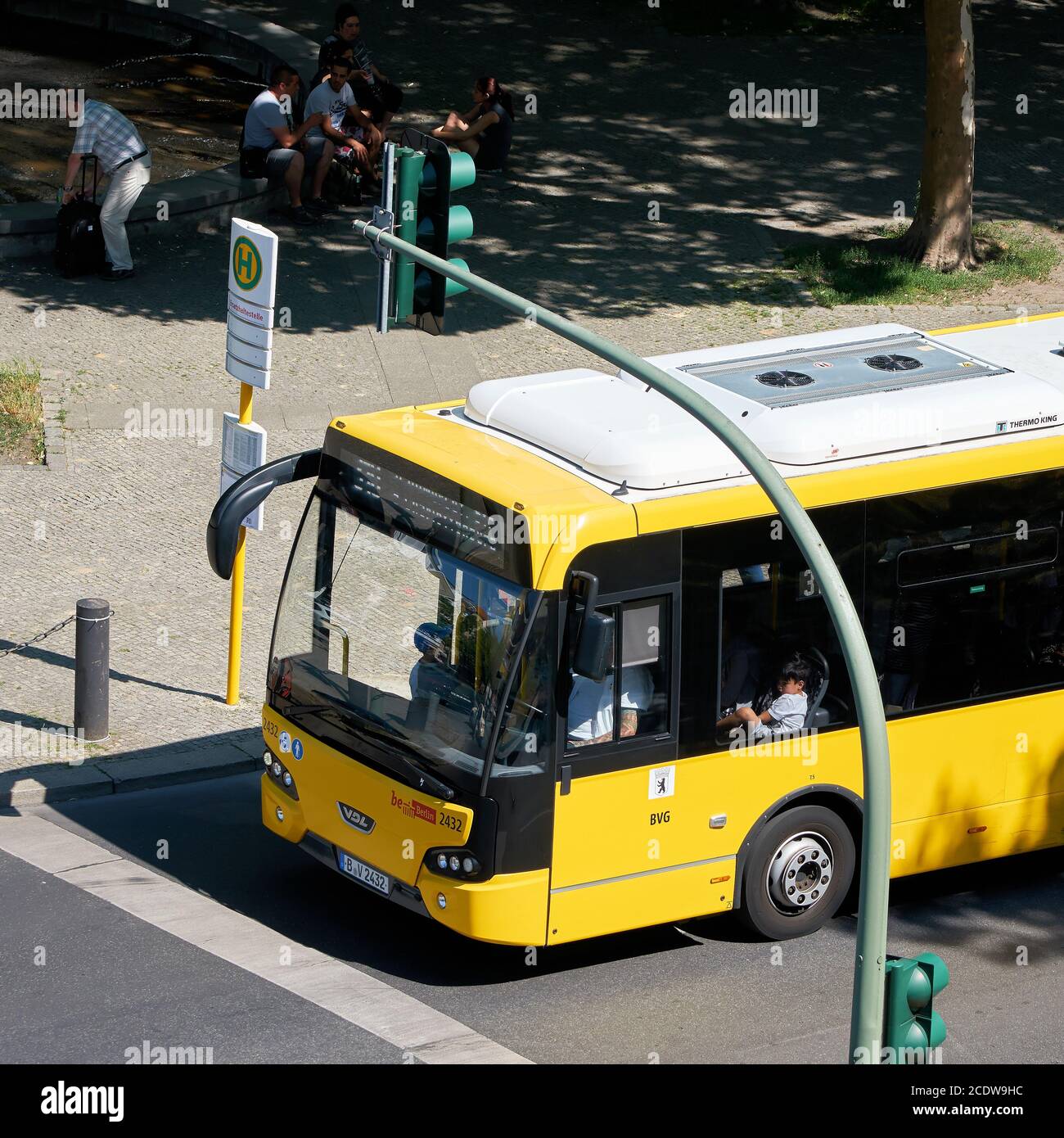 Gelbe Bus an einer Bushaltestelle im Bezirk Charlottenburg in der Innenstadt von Berlin. Stockfoto