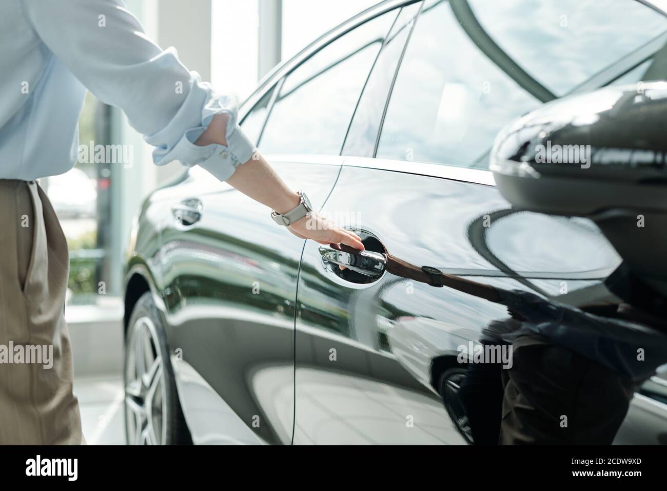 Hand von jungen eleganten Mann in Hemd und Hose gehen Um die Tür des Autos zu öffnen Stockfoto