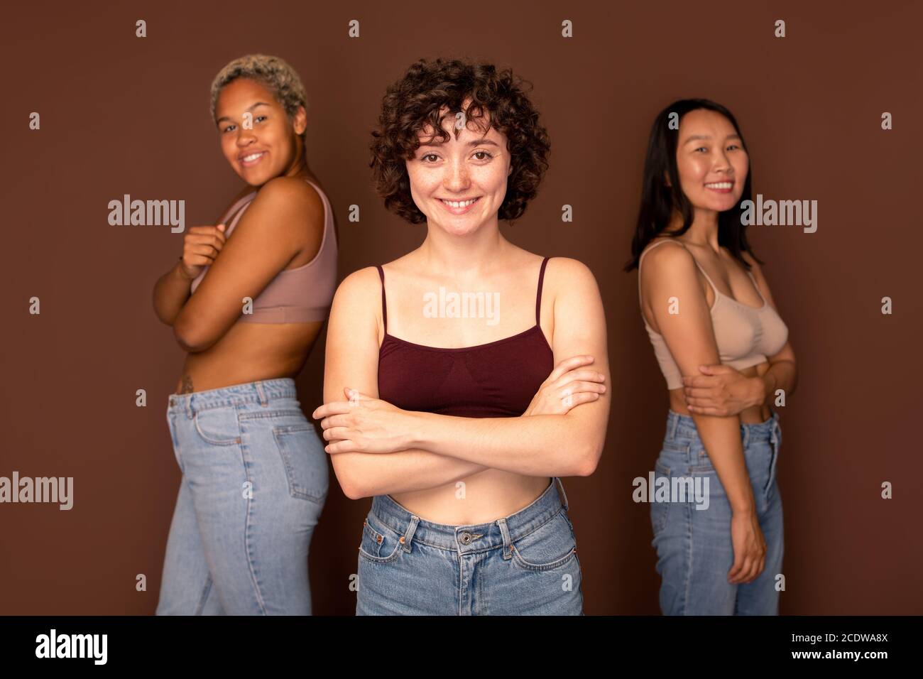 Junge schöne Brünette Frau vor zwei anderen stehen Frauen Stockfoto