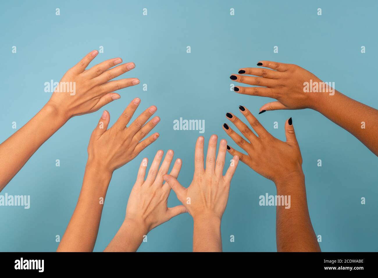 Drei Paar weibliche Hände verschiedener Ethnien mit verschiedenen Hautfarbe Stockfoto